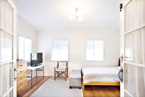 Dormitorio blanco aseado con muebles de madera — Foto de Stock