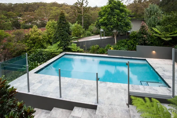 Moderna piscina con una valla de cristal en el suelo —  Fotos de Stock