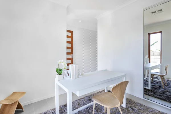 Sala de trabalho com paredes brancas e uma mesa com decoração simples — Fotografia de Stock