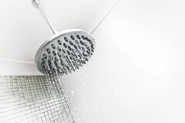Fluxos de água de um chuveiro redondo e prateado perto — Fotografia de Stock