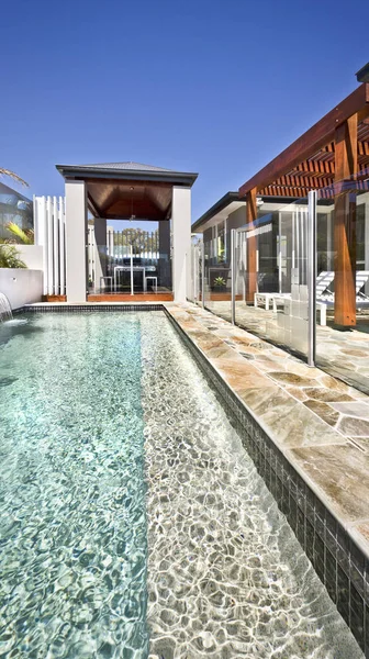 Moderna piscina con patio exterior y pilares de madera —  Fotos de Stock