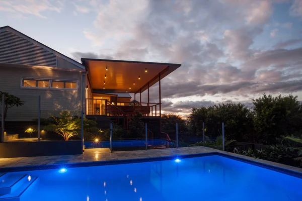 Modernt hotell med en pool på natten med ljus himmel — Stockfoto
