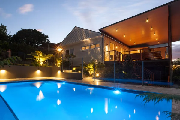 Hotel con luces intermitentes alrededor de la piscina por la noche —  Fotos de Stock