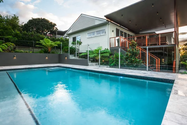 Moderna piscina con agua azul al lado de una mansión — Foto de Stock