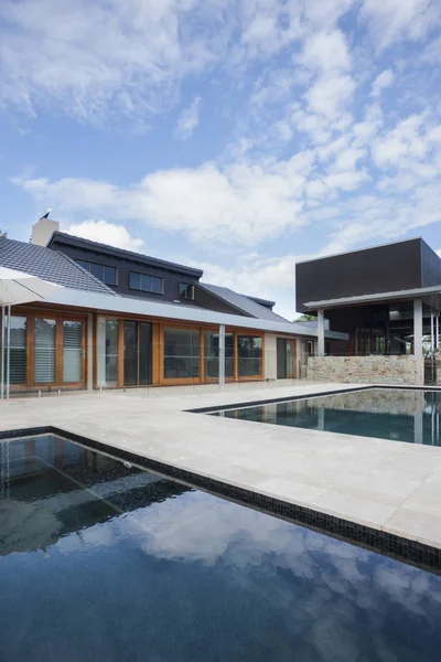 Mansión moderna frente a la piscina con cielo azul — Foto de Stock