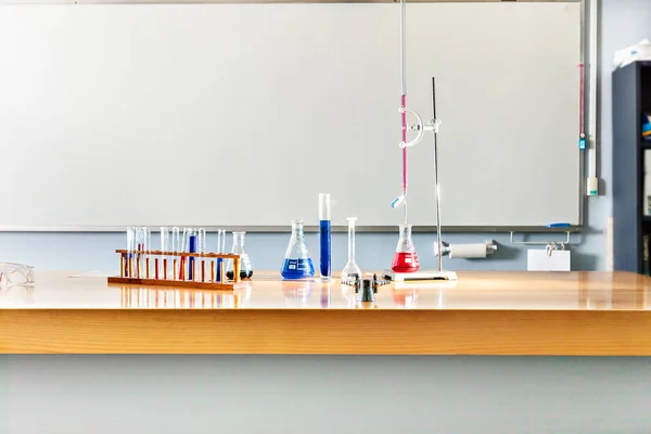 Artículos de laboratorio sobre la mesa con una pizarra blanca —  Fotos de Stock