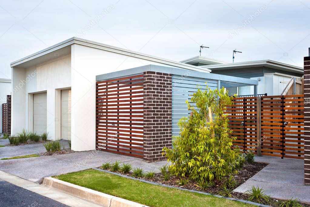 Luxury house front side with wooden gate and garden 