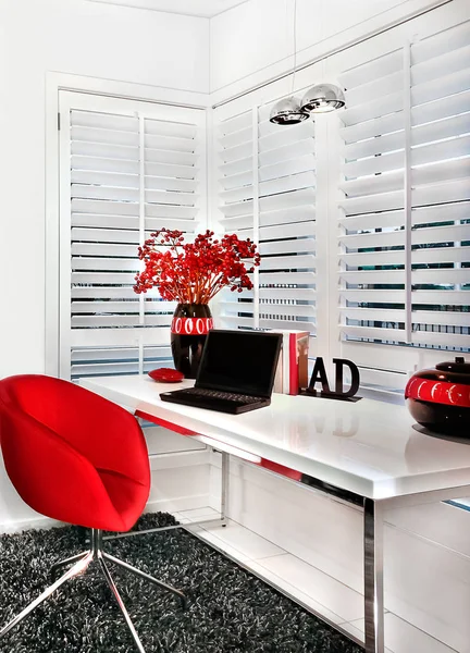 Closeup of a modern work room with a red chair a white table inc — Stock Photo, Image