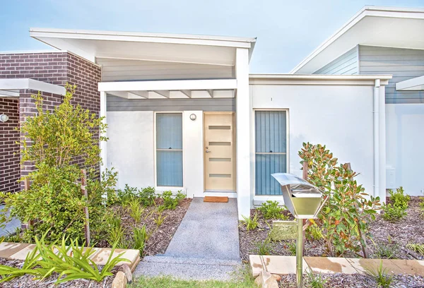 Modern huis ingang en deur naast een stenen tuin — Stockfoto