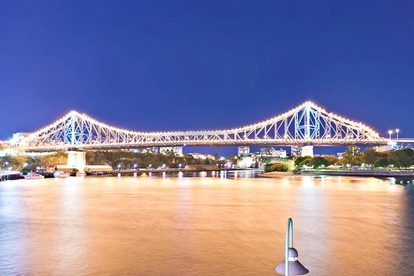 Rivier en een lange brug in de stad bij nacht — Stockfoto