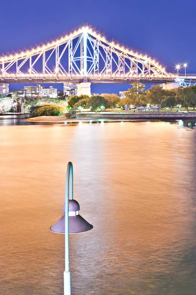 Rio amarelo e uma ponte com luz de rua — Fotografia de Stock