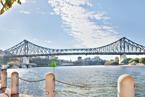 Flussufer und Betonpfeilerzaun mit Brücke — Stockfoto