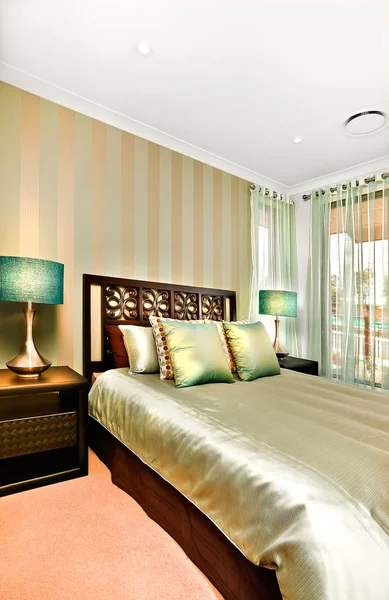 Seitenansicht eines King-Size-Bettes mit Glanzkissen und Bettdecke — Stockfoto