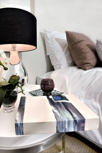 Livre et lampe sur une table près du lit dans une maison de luxe — Photo