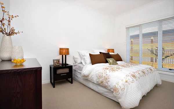 Роскошная спальня современного дома, включая белые простыни с h — стоковое фото