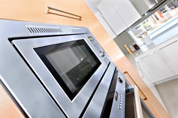 Close up of a modern oven in a luxury kitchen fixed to the wooden
