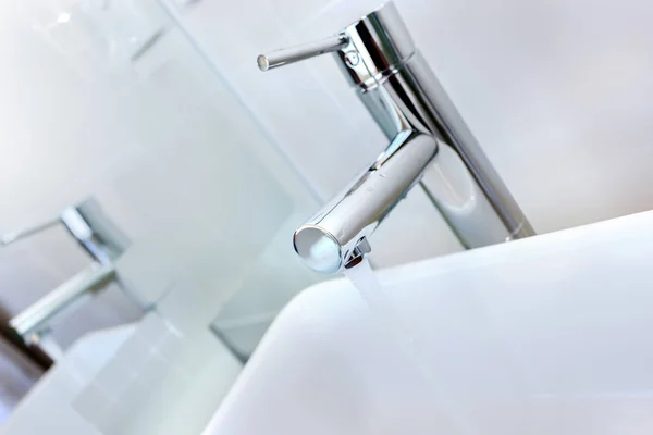 Acqua corrente di un rubinetto moderno nel bagno con lavabo — Foto Stock