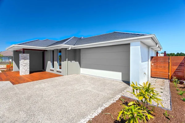 Casa moderna con garaje y patio trasero y cielo azul — Foto de Stock