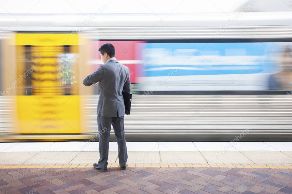 Businessman looking at watch for next train