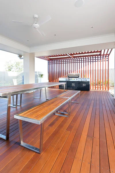 Mesa e bancos com um piso feito de longas barras de madeira — Fotografia de Stock