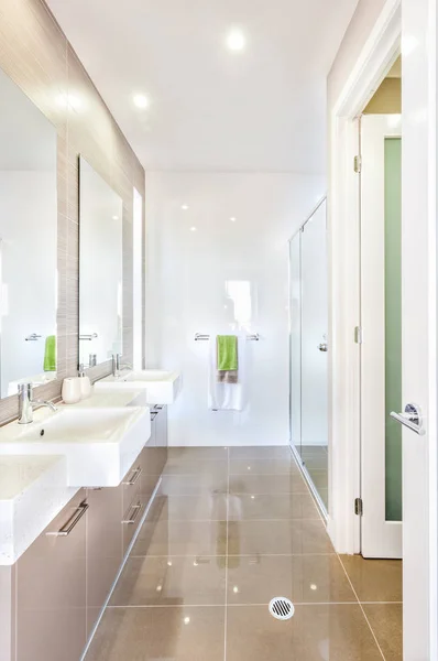 Um banheiro moderno com conjunto de wshstands e banheiro — Fotografia de Stock