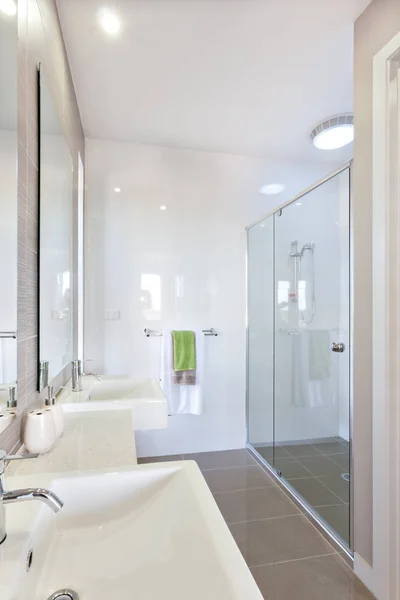 Nahaufnahme eines modernen Waschtisches mit einem silbernen Wasserhahn in der Nähe von Spiegel i — Stockfoto