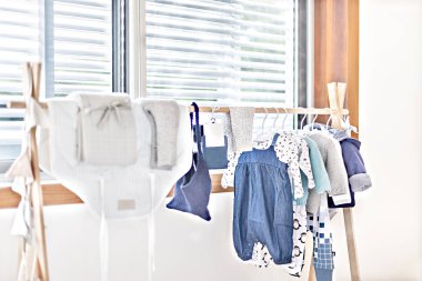 Pencerenin yanında asılı bebek bezleri veya çocuk elbiseleri