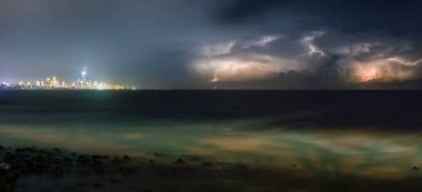 Fırtınalı havada, yıldırımlarla birlikte Avustralya okyanus kıyısının gece görüntüsü. Panoramik fotoğraf