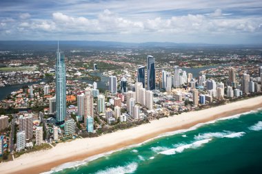 Büyük, modern bir şehrin önünde uzanan Long Beach Surfers Paradise, Queensland, Avustralya