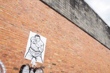 Brisbane, Avustralya - 17 Eylül 2013: Eski binanın tuğla duvarına ateş eden adamın resmi asıldı