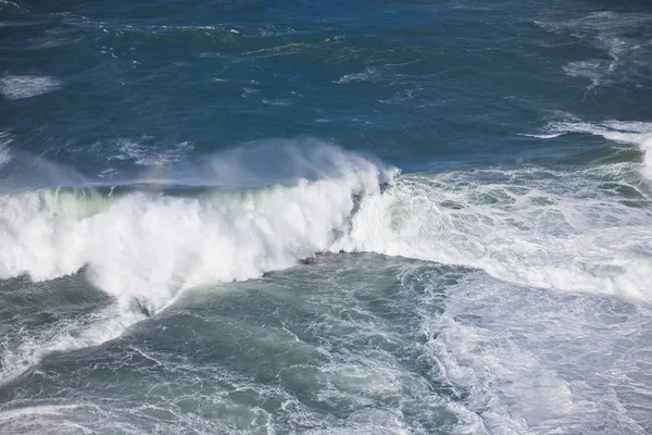 Пенные каменистые волны, бьющиеся в океане — стоковое фото