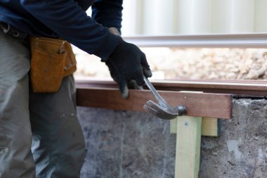 Tahtaya çivi çakan bir adam.