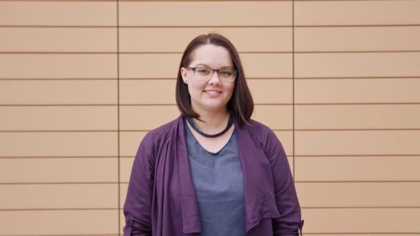 Young Lady Smiling against a Beige Background — Stok Video