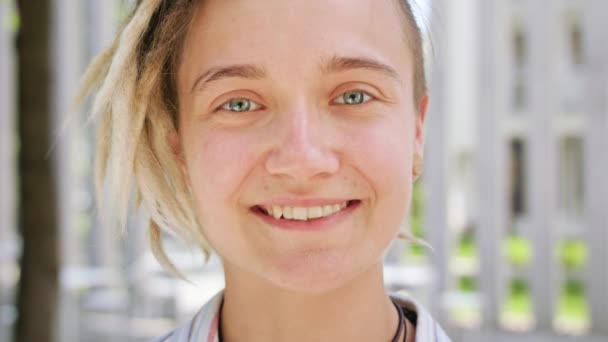 Joven dama con peinado moderno sonriendo al aire libre — Vídeos de Stock