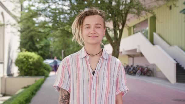 Jovem com penteado moderno sorrindo ao ar livre — Vídeo de Stock