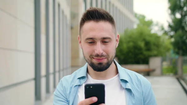 Man met baard met behulp van een telefoon in de stad — Stockfoto