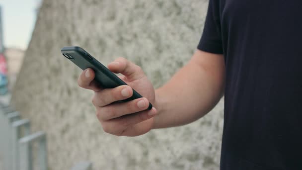 Primer plano de la mano de los hombres usando un teléfono al aire libre — Vídeo de stock