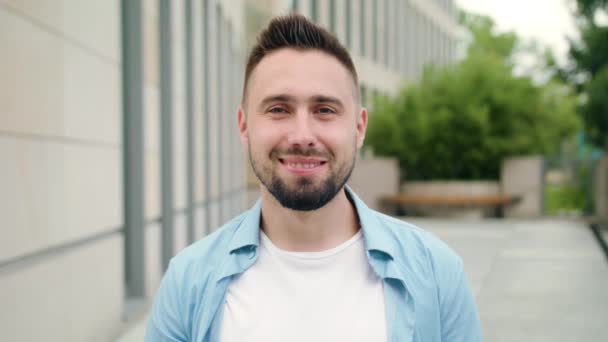 Hombre con barba sonriendo en la calle de la ciudad — Vídeos de Stock