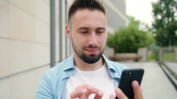 Άνδρας με γενειάδα χρησιμοποιώντας ένα τηλέφωνο στην πόλη — Αρχείο Βίντεο