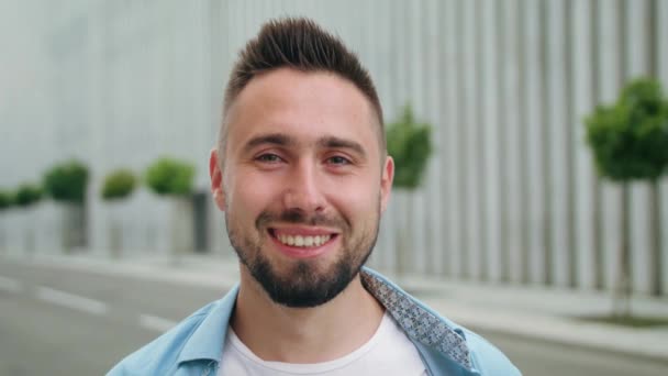 Hombre con barba sonriendo en la calle de la ciudad — Vídeo de stock