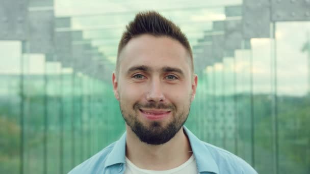Happy usmívající se muž s bradkou v prosklené budově — Stock video