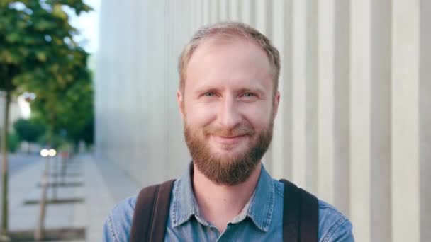 Joyeux homme aux cheveux rouges souriant avec barbe en ville — Video