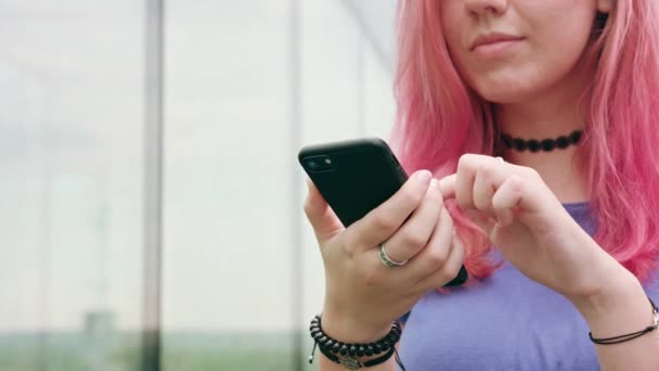 Mulher com cabelo rosa usando um telefone na cidade — Vídeo de Stock