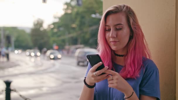 Mujer con el pelo rosa usando un teléfono en la ciudad — Vídeos de Stock