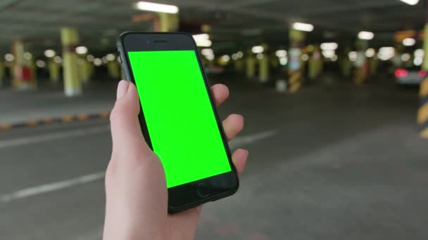 Eine Hand hält ein Telefon mit grünem Bildschirm — Stockvideo