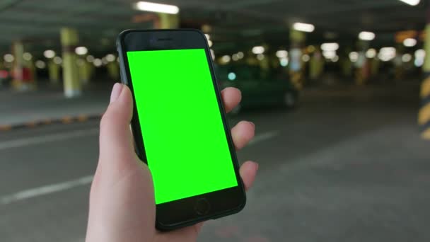 Eine Hand hält ein Telefon mit grünem Bildschirm — Stockvideo