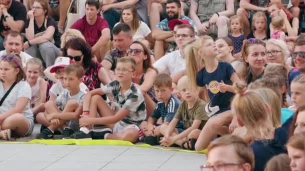 A Crowd of People Sitting on the Ground in Town — Stock Video