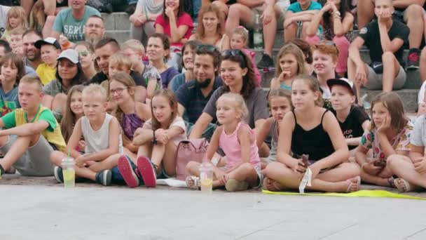 Tłum ludzi siedzi na ziemi w mieście — Wideo stockowe