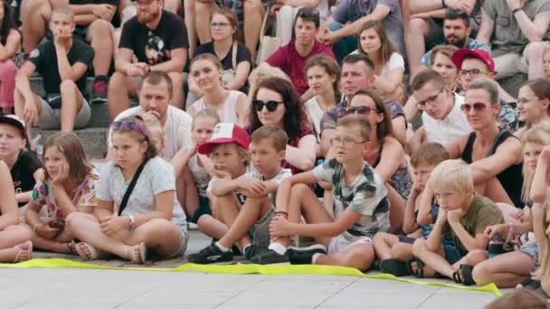 Une foule de gens assis sur le sol en ville — Video