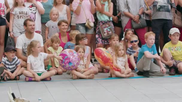 A Crowd of People Sitting on the Ground in Town — Stock Video